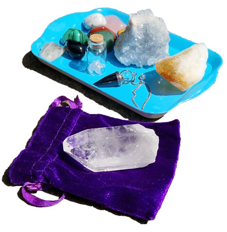 healing crystals on a blue tray and large clear quartz healing directional crystals on a purple velvet bag healing with Cheryl Colpman